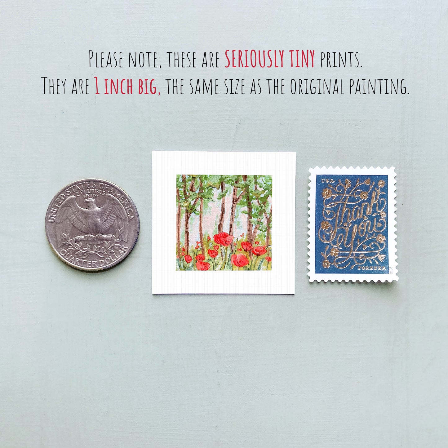 three small artworks: a silver coin, a framed print of a forest scene with red flowers, and a blue postage stamp with gold lettering.