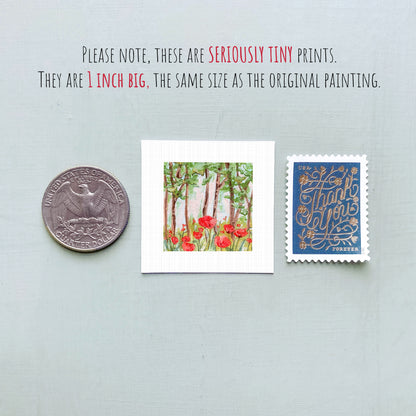 three small artworks: a silver coin, a framed print of a forest scene with red flowers, and a blue postage stamp with gold lettering.