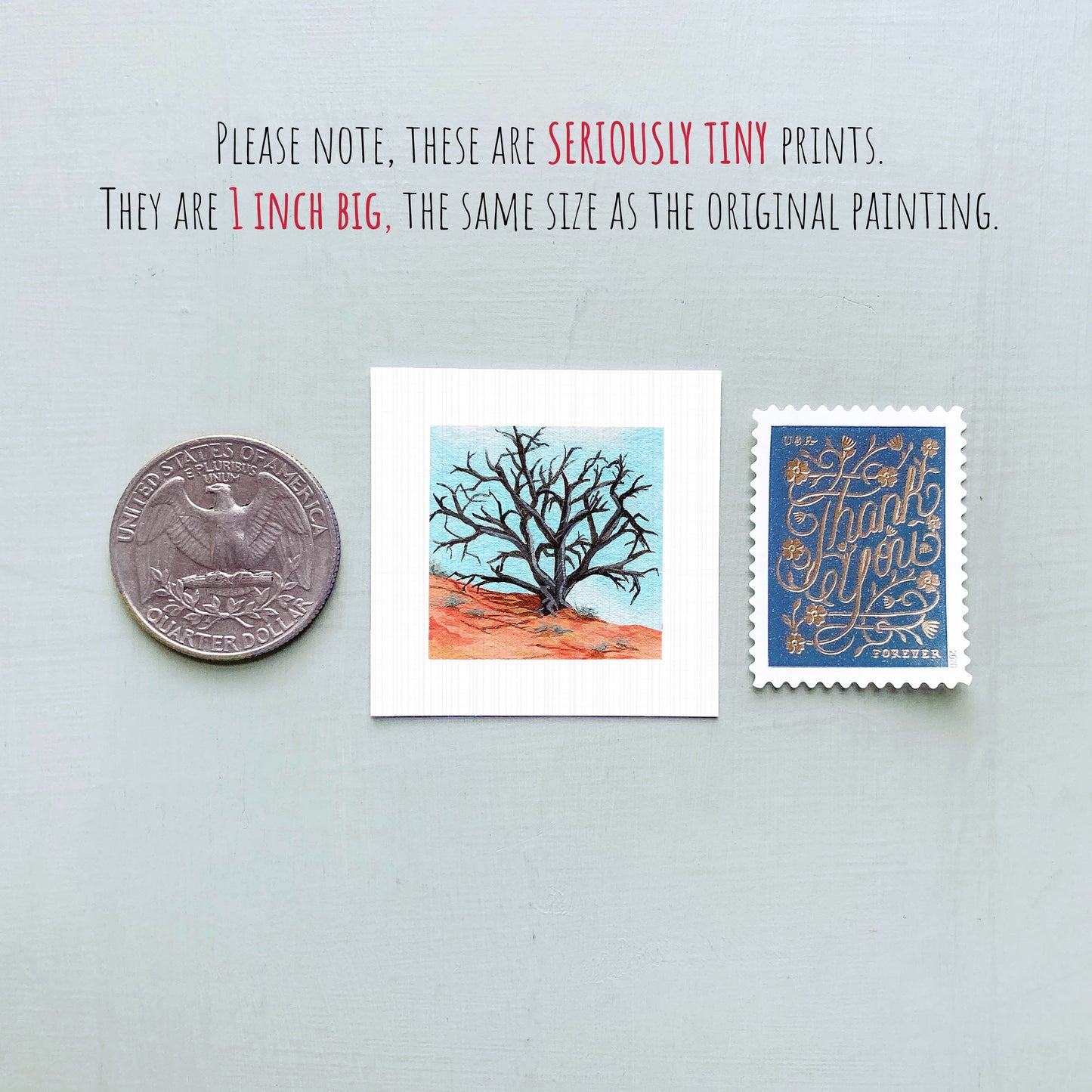three small artworks: a quarter, a square print of a tree, and a blue postage stamp with gold lettering.