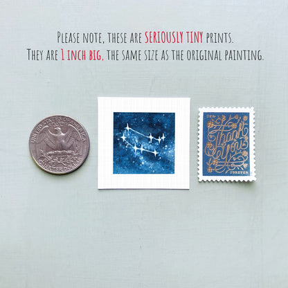 three small prints: a quarter, a square print of a starry night sky, and a postage stamp.