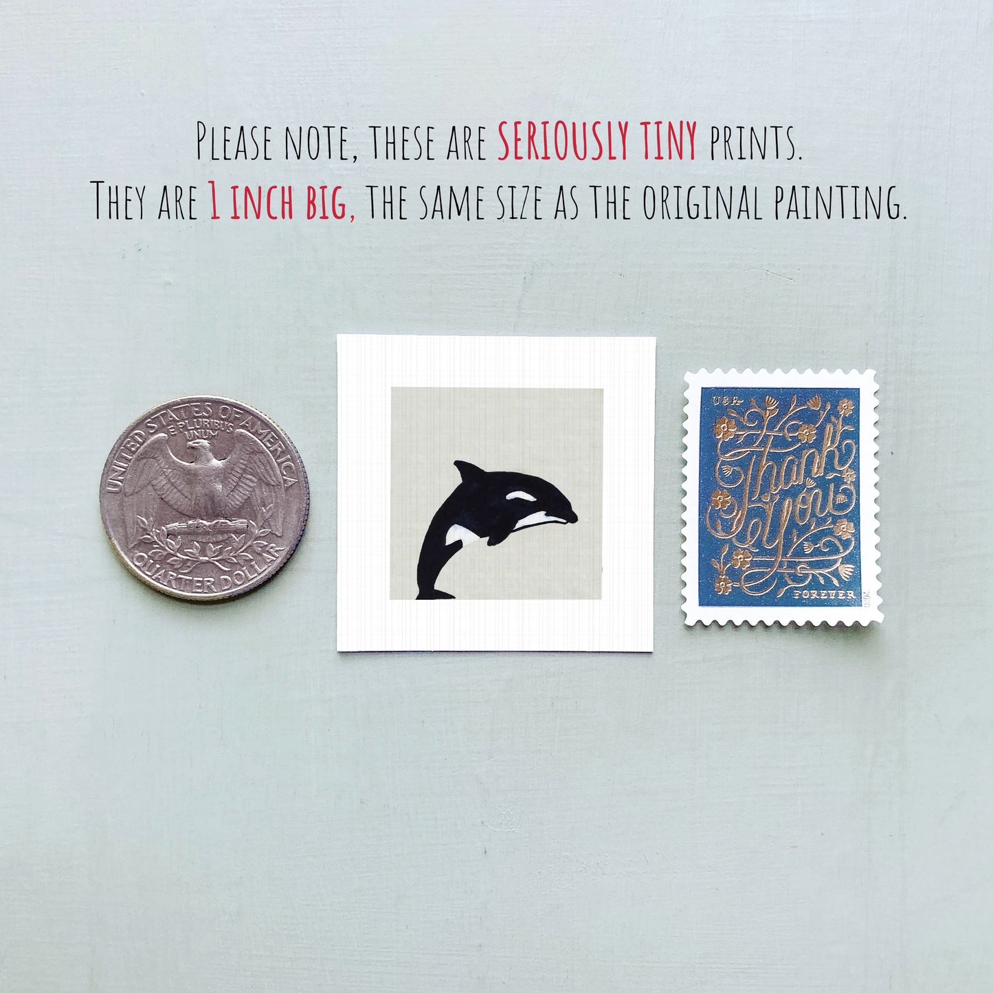 three small prints: a quarter, a square print of a black and white whale, and a blue postage stamp with gold lettering.