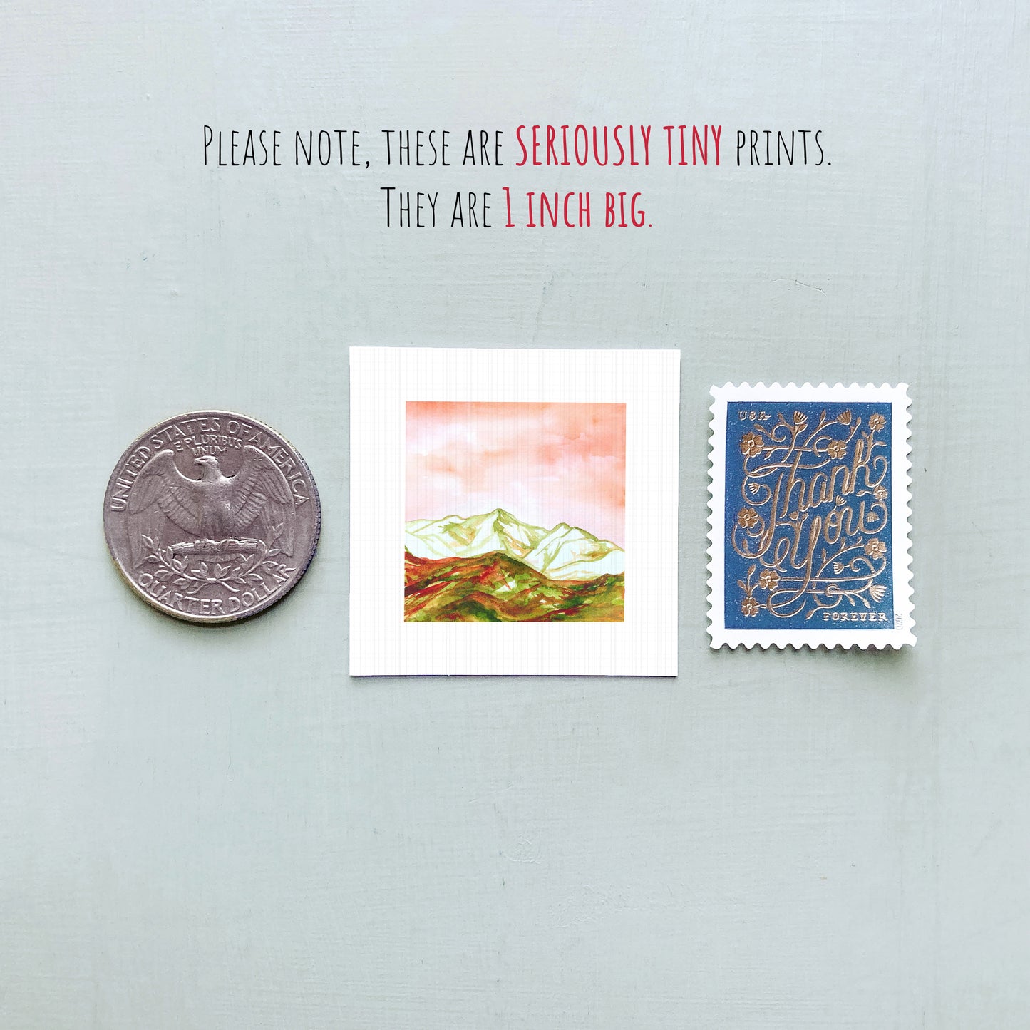 a collection of three small items: a United States quarter, a small square print, and a blue postage stamp.