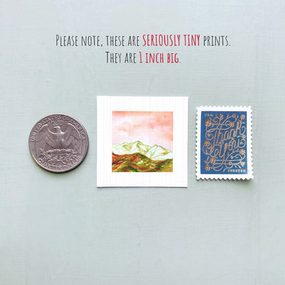 a collection of three small items: a United States quarter, a small square print, and a blue postage stamp.