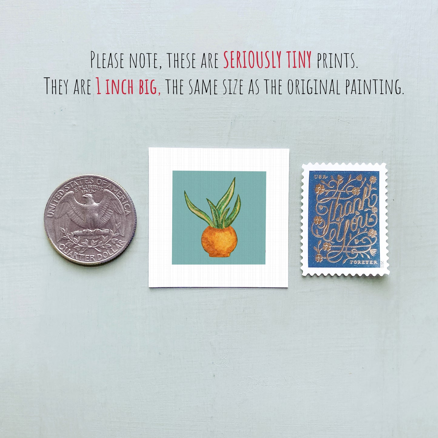 three small artworks: a quarter, a square print of an orange with leaves, and a postage stamp.